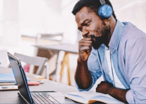 student studying at a computer listening with headphones
